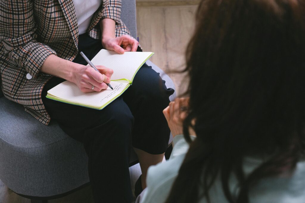 Psychoterapia stacjonarna Psychoterapeuta zapisujący notatki w trakcie rozmowy z klientem